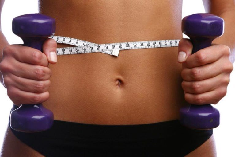 Fitnesa hanteles fit meitenes rokās